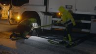Ice Road Rescue - Extremrettung in Norwegen – Thord bekommt Hilfe vom Fahrer eines Lastwagens, um einen Riemen am Vorderrad eines Lieferwagens zu befestigen. (National Geographic)