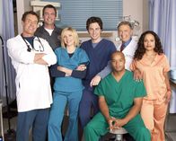 Scrubs - Die Anfänger – (4. Staffel) - Die Belegschaft des Sacred Heart Hospitals muss täglich mit neuen Überraschungen rechnen: J.D. (Zach Braff, M.), Turk (Donald Faison, 3.v.r.), Dr. Phil Cox (John C. McGingley, 2.v.r.), Hausmeister (Neil Flynn, 2.v.l.), Dr. Bob Kelso (Ken Jenkins, 2.v.l.), Elliot (Sarah Chalke, 3.v.l.), und Carla Espinosa (Judy Reyes, r.) ...