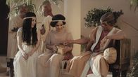 Universum History – Ein Mann und zwei Frauen sitzen auf einer Bank. Die Frau in der Mitte hat eine Schale mit Essen in den Händen. Der Mann greift in die Schale.