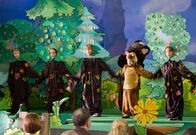 In aller Freundschaft – Die Theatervorstellung "Der Bär im Zauberwald". Bastian Marquardt (Johann Lukas Sickert, 3. von rechts), Shakira Schmidt (Sophie Margo Gottwald, im Bärenkostüm, 2. von rechts) und Jonas Heilmann (Anthony Petrifke, rechts) spielen mit.
