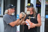 Die Pythonjäger - Einsatz in den Everglades – Dusty Crum and Jay Starr outside of gas station eating and playing with baby python