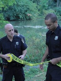 Ein perfekter Mord – Police set up a crime scene after finding a dead body in a river.