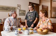 Rentnercops – Frühstück: Günter Hoffmann (Wolfgang Winkler, l.) beschwert sich bei Enkelin Lotta (Katharina Witza, M.) - fair gehandelt schmeckt ihm nicht. Heidrun (Verena Plangger, r.) hält sich zurück.