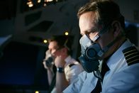 Mayday - Alarm im Cockpit – REENACTMENT- Der Erste Offizier Matthew Bell (gespielt von Cody Ray Thompson) setzt seine Sauerstoffmaske auf, während sich Kapitän Doug Lampe (gespielt von Jonathan Purdon) auf das Fliegen des Flugzeugs konzentriert, nachdem an Bord von UPS Flug 6 ein Feuer ausgebrochen ist (Cineflix International Media/Ian Watson).