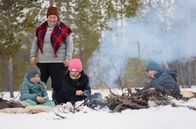 Zu Tisch ... – Ein Feuer im Freien: Hilde Danielsen bereitet mit den Kindern das Abendessen vor.