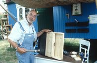 Löwenzahn Classics – Peter (Peter Lustig) baut einen Fledermaus-Nistkasten vor seinem Bauwagen.