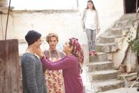 Ein Fisch namens Liebe – Fatma (Nursel Köse, r.) tätschelt Mehmet (Luk Piyes, l.) die Wange, um ihn vom Hof des Hauses zu verscheuchen, weil sie mit Vicky (Christiane Paul, M.) alleine kochen will.