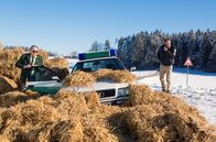 Hubert ohne Staller – Die Bremsen am Streifenwagen haben versagt. Hubert (Christian Tramitz, r.) und Girwidz (Michael Brandner, l.) landen in einem Haufen aus Strohballen und kommen mit dem Schrecken davon.