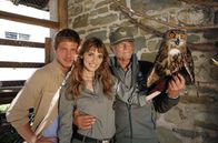 Die Bergpolizei – Alle Helfer der Forstwache Innichen: Pietro (Terence Hill, rechts), Silvia (Gaia Bermani Amaral, Mitte) und Giorgio (Gabriele Rossi, links) freuen sich gemeinsam über das geheilte Uhu-Weibchen, das bald in die Freiheit entlassen werden kann.