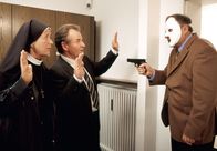 Um Himmels Willen – Schwester Lotte (Jutta Speidel, l.) und Bürgermeister Wöller (Fritz Wepper, M.) werden von einem Bankräuber (Gerhard Garbers, r.) mit der Waffe bedroht.