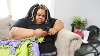 Mein Leben mit 300 kg – Ashley sits on couch on phone