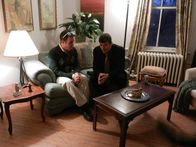 Love Kills – L-R: Rob Andrew (Guy Olivieri) and James Pavatt (Actors, Johnson Cooley) are sitting on the couch, talking.
