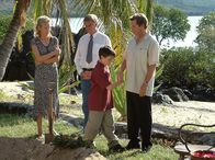 Am Kap der Liebe – Byron Blair (Siegfried Rauch), Anne van Gaard (Claudine Wilde) und ihr kleiner Sohn Felix (Aaron Donovan) zeigen Jan Hansen (Sigmar Solbach, re.) die Insel, die er von seinem kürzlich verschiedenen Vater geerbt hat.