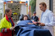 In aller Freundschaft – Die Notärztin (Caren Seifert, li.) bringt Monika Vietmann (Anna Thalbach, mi.) mit starken Bauchschmerzen aus der JVA in die Sachsenklinik. Dort angekommen, muss Dr. Martin Stein (Bernhard Bettermann, re.) der aggressiven Monika Vietmann erst einmal klar machen, dass in der Sachsenklinik andere Verhaltensregeln gelten.