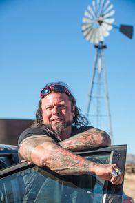 Airplane Repo - Die Inkasso-Piloten – Danny Thompson standing behind a car door.