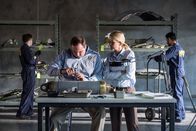Mayday - Alarm im Cockpit – Ayr, ON - REENACTMENT - Lorenda Ward, played by Marnie Robinson and an NTSB crash investigator, played by Dimitri Vantis, inspect a cracked actuator as other NSTB crash investigators, played by background performers, assess evidence. (Cineflix 2017/Darren Goldstein)
