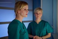 In aller Freundschaft – Dr. Roland Heilmann hat die schwere und hochriskante OP zwar überstanden, aber er hatte etwa 45 Minuten Kreislaufstillstand. Dr. Lea Peters (Anja Nejarri, links) soll die Ärzte als Neurochirurgin unterstützen. Sie und Dr. Kathrin Globisch (Andrea Kathrin Loewig) haben Rolands Körpertemperatur auf 33 °C gesenkt, um eventuelle Schäden im Gehirn möglichst gering zu halten. Doch niemand weiß, wie viel Schaden Rolands Hirn schon genommen hat. Für Lea ist die Situation fast unerträglich - der Messerangriff galt eigentlich ihr.