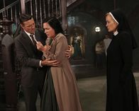 American Horror Story – Jahr 1964: Jude (Jessica Lange, r.) ist mittlerweile überzeugt, dass die echte Anne Frank (Franka Potente, M.) in Briarcliff Zuflucht gefunden hat. Plötzlich taucht jedoch der Ehemann (David Chisum, l.) der Patientin auf und behauptet, Anne sei in Wirklichkeit seine geliebte Frau Charlotte Reilly ...