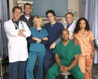 Scrubs - Die Anfänger – (5. Staffel) - Die Belegschaft des Sacred Heart Hospitals muss täglich mit neuen Überraschungen rechnen: J.D. (Zach Braff, M.), Turk (Donald Faison, 3.v.r.), Dr. Phil Cox (John C. McGingley, 2.v.r.), Hausmeister (Neil Flynn, 2.v.l.), Dr. Bob Kelso (Ken Jenkins, 2.v.l.), Elliot (Sarah Chalke, 3.v.l.), und Carla Espinosa (Judy Reyes, r.) ...