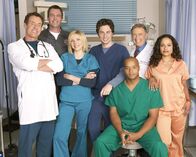 Scrubs - Die Anfänger – (4. Staffel) - Die Belegschaft des Sacred Heart Hospitals muss täglich mit neuen Überraschungen rechnen: J.D. (Zach Braff, M.), Turk (Donald Faison, 3.v.r.), Dr. Phil Cox (John C. McGingley, 2.v.r.), Hausmeister (Neil Flynn, 2.v.l.), Dr. Bob Kelso (Ken Jenkins, 2.v.l.), Elliot (Sarah Chalke, 3.v.l.), und Carla Espinosa (Judy Reyes, r.) ...
