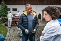 Watzmann ermittelt – Jerry Paulsen (Peter Marton, 2.v.r.) führt mit Conny Haas (Eva-Maria Reichert, r.), der Chefin der Malerfirma, ein erstes Verhör am Tatort. Sonja Bitterling (Genoveva Mayer, im HG. mit Komparse)