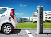Mit offenen Karten – Elektroauto auf Ladeplatz vor Architekturbürogebäuden - Carsharing-Pendlerladestation