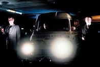 Ipcress - Streng geheim – In einer Parkgarage stehen Harry Palmer (Michael Caine, li.), sein Kollege Carswell, genannt Jock (Gordon Jackson, re.), und ein Sanitäter für die Lösegeldübergabe bereit.
