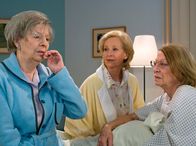 In aller Freundschaft – Ingeborg Riegel (Ulina am Ende, rechts) ist gerührt, dass sich Liselotte Günther (Gerlinde Locker, Mitte) und Doris Klump (Ilse Strambowski) so sehr um sie bemühen. Beim Öffnen einer eingeschmuggelten Sektflasche hat Doris plötzlich kein Gefühl mehr in ihren Händen und auch der Mund ist taub.