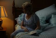 Tödliche Stille – An older woman sits on her bedside.
