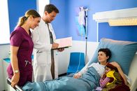 Bettys Diagnose – Elisabeth Hertz (Henrike Hahn, l.) und Dr. Julius Walden (Constantin Lücke, 2.v.l.) stehen am Krankenbett von Iris Herdinger (Liza Tzschirner, 2.v.r.), die von Ihrer Tochter Jonna Herdinger (Soraya Maria Efe, r.) besucht wird. Alle sind sehr erleichtert, dass die OP gut verlaufen ist.