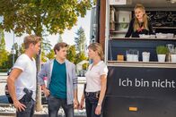 SOKO München – Dominik Morgenstern (Joscha Kiefer, l.) und Resi Schwaiger (Mersiha Husagic, r.) befragen Daniel Steeger (Juri Senft, M.) vor dem Food-Truck von Jana Herzog (Eva Nürnberg, im Wagen ).