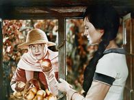 Schneewittchen – Die verkleidete böse Stiefmutter (Marianne Christine Schilling) bietet Schneewittchen (Doris Weikow) einen vergifteten Apfel an.