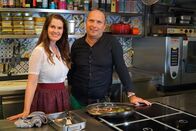 Hoagascht – Conny Bürgler (links) und Emanuel Weyringer (rechts) in der Küche vom Restaurant Weyringer mit einer frisch gegrillten Forelle in der Pfanne