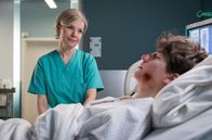 In aller Freundschaft – Dr. Kathrin Globisch (Andrea Kathrin Loewig) wacht Uhr im ERSTEN. Dr. Kathrin Globisch (Andrea Kathrin Loewig) wacht am Bett des bei dem Massenunfall in der Leipziger Innenstadt schwerverletzten Patienten (Juri Winkler).