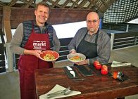 MarktFrisch – Unter dem extravaganten Dach der Markthalle in Mannheim versucht Profikoch Frank Brunswig (re.) Nicht-Koch Jens Hübschen (li.) wieder das Kochen beizubringen. Auf der Speisekarte steht dieses Mal: Doppelt paniertes Ei auf Hirse-Gemüsebeet mit Senfsoße. Und zum Nachtisch gibt es Nusstorte an Apfelkompott und Orangen-Gelee.