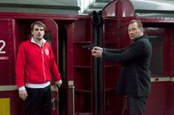 Huck – Showdown am Bahnhof: Rainer Gaissert (Marko Dyrlich, r.) hält den Cannstatter Star-Torwart Petram Stanic (Marian Kindermann, l.) mit der Waffe in Schach.