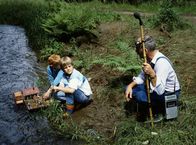 Löwenzahn Classics – Peter Lustig fragt die beiden Jungs, ob man an dieser Stelle gut das Plätschern des Baches aufzeichnen kann. Er ist auf der Suche nach einer geeigneten Stelle für seine Bach-Komposition.