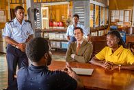 Death in Paradise – Henry Baptiste (Solomon Israel, 2. v. l.) gerät unter Mordverdacht und wird auf dem Polizeirevier vor Marlon Pryce (Tahj Miles, l.), Darlene Curtis (Ginny Holder, M.), Detective Neville Parker (Ralf Little, 2. v. r.) und Naomi Thomas (Shantol Jackson, r.) befragt.