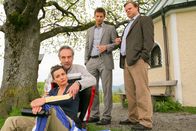 Die Rosenheim-Cops – Die Rosenheimer Kommissare Hansen (Igor Jeftic, 2.v.r.) und Hartl (Tobias A. Grimm, r.) recherchieren im beruflichen Umfeld des Opfers und befragen das Ehepaar Sendlinger (Daniel Friedrich, 2.v.l.; Katja Keller, l.).