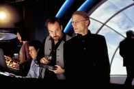 Die Truman Show – Sein ganzes Gefolge, die Techniker, Redakteure, Assistenten, folgen Christof (Ed Harris, r.), dem Erfinder, Produzenten und Regisseur der Truman Show, völlig blind. Nicht einmal Christofs Kontrollraum-Direktor (Paul Giamatti, 2.v.re.) hat Gewissensbisse oder moralische Bedenken ...