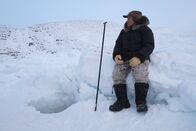 One Strange Rock - Unsere Erde – Lukasi Naappaluk waits by a hole dug out of the ice - he hopes to find some mussels for the Inuk to use to supplement their diet.