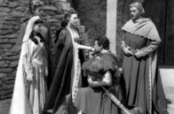 Die Ritter der Tafelrunde – Sir Lancelot (Robert Taylor, 2.v.r.) küsst Königin Guinevere (Ava Gardner, Mi.) die Hand. Seine Frau Elaine (Maureen Swanson, li.), Percival (Gabriel Woolf, 2.v.l.) und König Artus (Mel Ferrer, re.) wohnen der Szene bei.