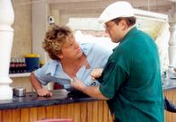 Zum 60. Geburtstag von Hape Kerkeling: Club Las Piranjas – 00 Uhr. Der eifersüchtige Karl-Heinz (Michael Brandner, rechts) macht Animateur Edwin (Hape Kerkeling, links) unmissverständlich klar, die Finger von seiner Frau zu lassen.