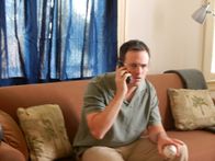 Love Kills – Rob Andrew (Actor, Guy Olivieri) is sitting on the couch while on the phone.