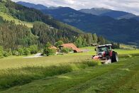 Ich, Bauer – Wiese mit Traktor Bauer Jakob Schabernig, im Hintergrund sein Hof