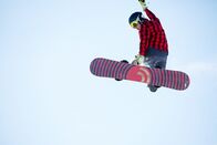 Snowboard: Weltcup – Bild von jungen Athleten springen mit Snowboard gegen blauen Himmel Hintergrund