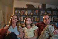 First Day - Ich bin Hannah – Hannahs Eltern Amanda (Jo Hunt, l.) und Steve (Mark Saturno, r.) versuchen Hannah (Evie MacDonald, M.) beim Fernsehgucken auf anderen Gedanken zu bringen.