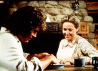 Unsere kleine Farm – Caroline (Karen Grassle, r.) und ihr Mann Charles (Michael Landon, l.) überlegen, ob sie die schlafenden Kinder wecken sollen, da es Zeit wird , zum Maskenball zu gehen.