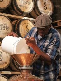 Moonshiners: Master Distiller – Leo pouring mash into still