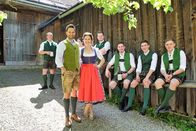 Servus Musikantenstammtisch – Moderatoren Conny Bürgler und Richard Deutinger vor dem Woferlstall in Bad Mitterndorf, im Hintergrund Mitglieder der Volkstanzgruppe Altaussee